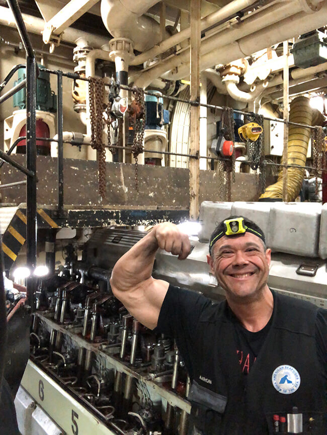 Maritime Engineer Aaron Braaen in the engine room of the American Triumph