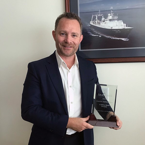 American Seafoods' Rasmus Sorensen holds an award from SeaShare